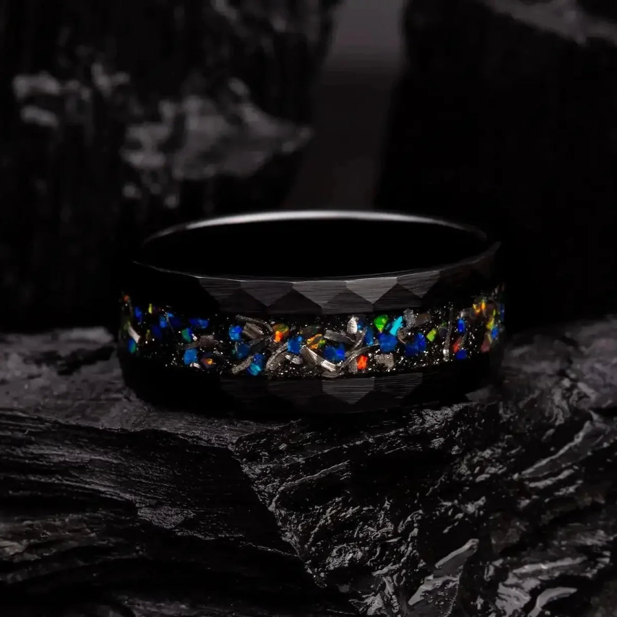 8mm black hammered tungsten ring with blue opal and meteorite. The ring is laying on a black coal