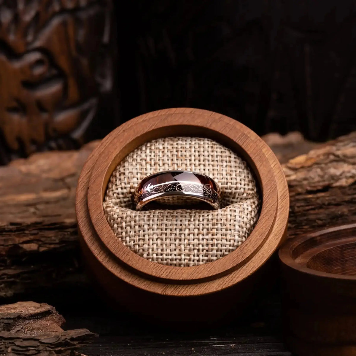 Silver tungsten ring with meteorite, rosewood and arrow sign. The ring is placed inside a round wooden box