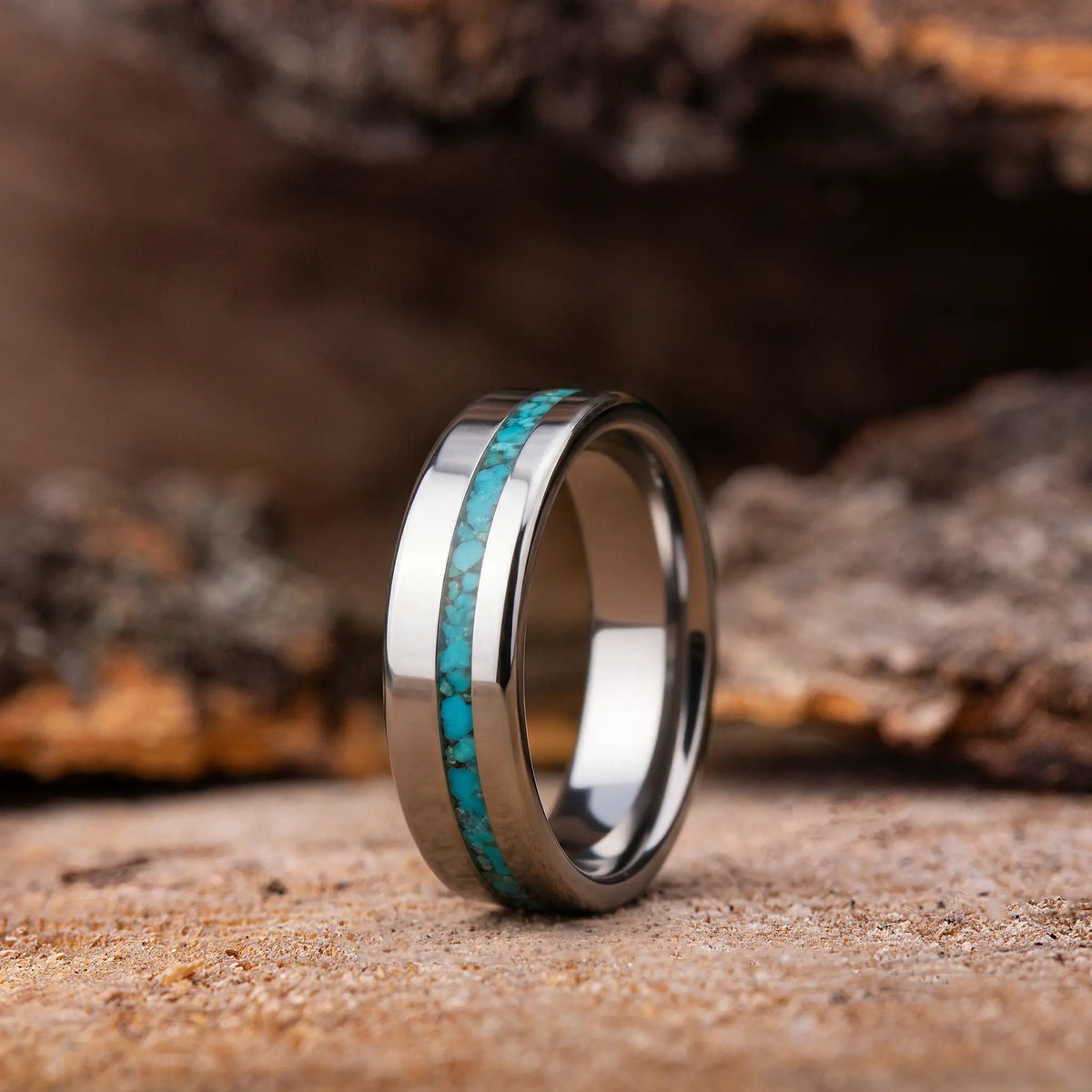 Silver ring with turquoise inlay on a wooden surface