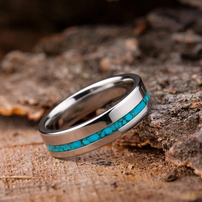Silver ring with turquoise inlay on a wooden surface